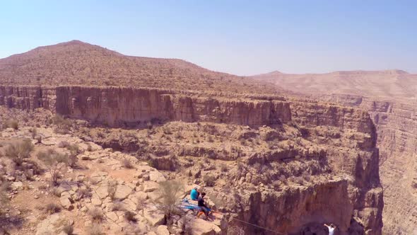 A man balances while tightrope walking and slacklining across a canyon