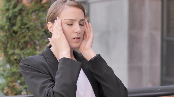 Stressed Young Businesswoman with Headache Sitting Outdoor