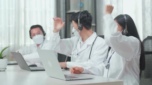 Success Of Three Asian Doctors With Stethoscopes In Headsets And Masks Working As Call Centre Agents