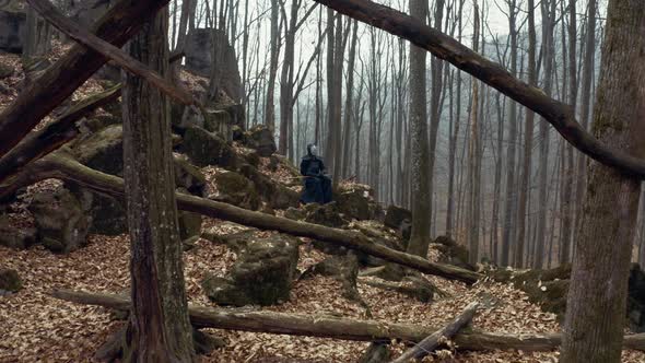 Concentrated Man with a Japanese Sword, a Katana Practicing Iaido in a Pine Forest, Wide Angle