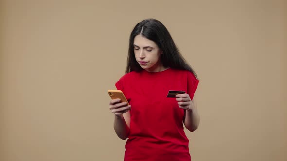 Portrait of a Model with Natural Beauty Makes an Online Purchase Using a Credit Card and Smartphone