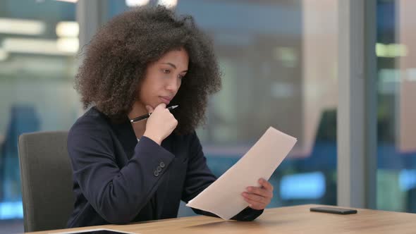 African Businesswoman Reading Documents at Work
