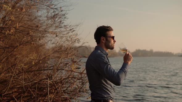 Man Drinking Wine On Sunrise. Winemaker Sommelier Close Up Smelling At Sunset. Man Holding Glass.