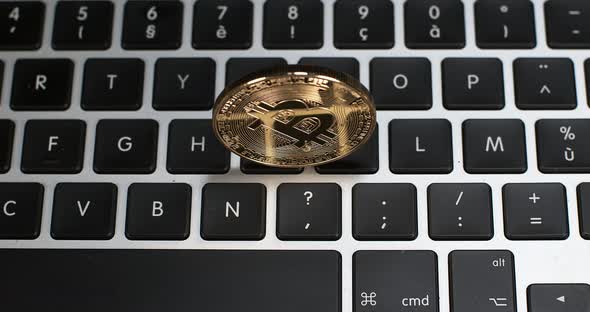Bitcoins on Computer Keyboard Background, Slow Motion 4K