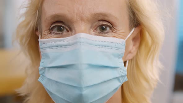 Close Up of Mature Woman in Medical Mask on Blurred Background