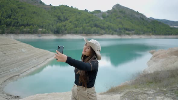 Young Darkhaired Woman Takes Selfies By Lake Pushin and Pushout