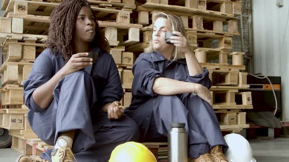 Relaxed Women in Uniform Sitting and Drinking Coffee