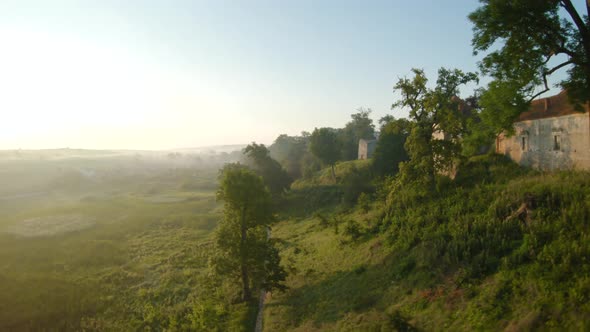 Colorful Hot Air Balloons Fly Over the Medieval Castle and Lake in the Morning Fog. Maneuverable