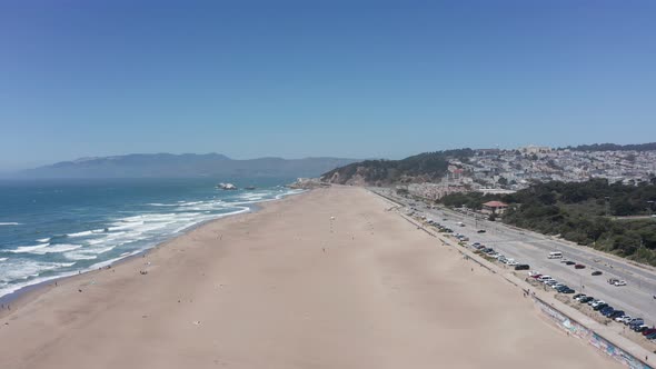 Wide rising aerial shot of Ocean Beach towards Land's End in San Francisco. 4K