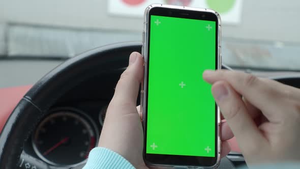 a man in a car holding a phone green screen