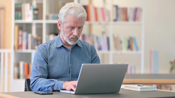 Serious Old Man Using Laptop