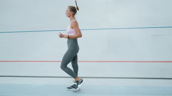 Handicapped Athlete Jogging on Stadium. Female Runner Exercising on Sports Track