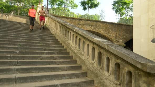 A couple running on stairs in a city as a workout
