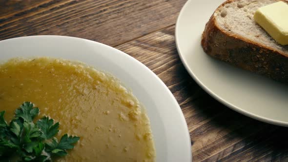 Bowl Of Soup And Bread On Wooden Table