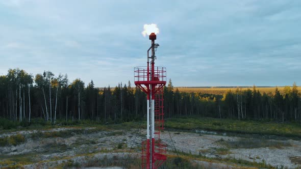 A Drone Takes Off Over a Burning Torch at an Oil Field in the Swamps of Siberia