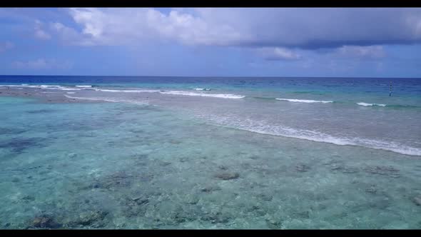 Aerial flying over tourism of idyllic sea view beach vacation by aqua blue water and white sand back