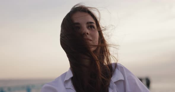 Young Woman Amazedly Looking on the Overcast Windy Sky