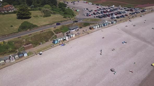 A descending aerial view of visitors enjoying the beautiful pebble beaches of Budleigh Salterton, a