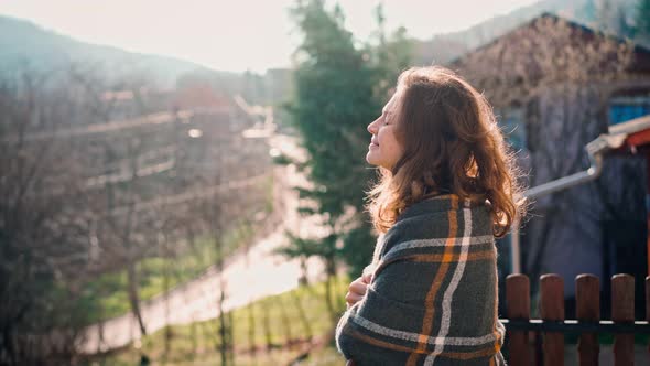 An Attractive Young Woman Enjoying Fresh Air While Standing on a Balcony