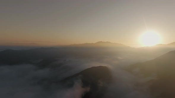 Sunrise through the clouds over the tops of the canyon in Malibu Canyon, Calabasas, California, USA