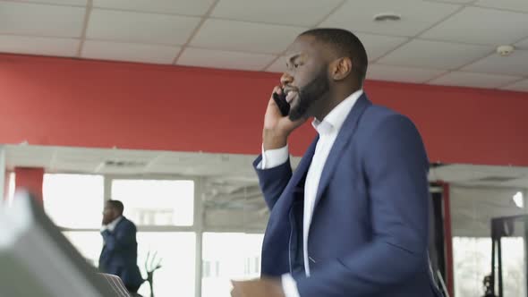 Successful Businessman Running on Treadmill and Talking on Cellphone at the Gym