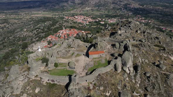 Drone camera captures a close up view of the boulders and rocks surrounding Monsanto Castle.