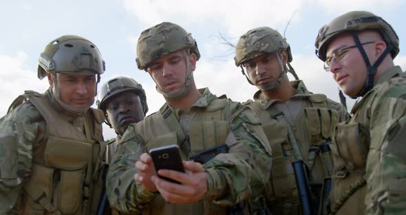 Front view of military soldiers using mobile phone during training 4k