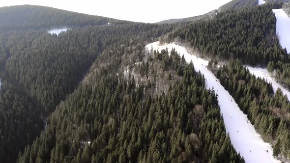 Drone flight over a group of people skiing in the ski resort during winter season.