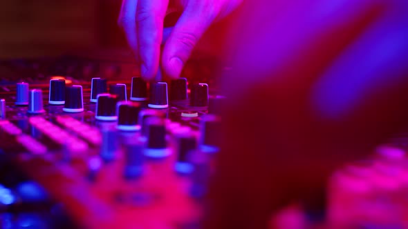 Sound Engineer Works at Mixer in Neon Light Closeup