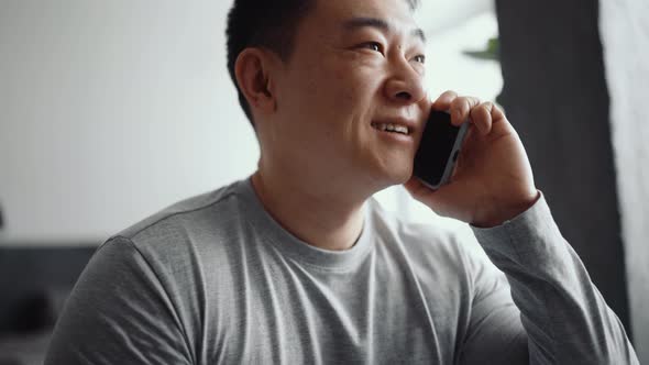 Asian positive man talking by phone