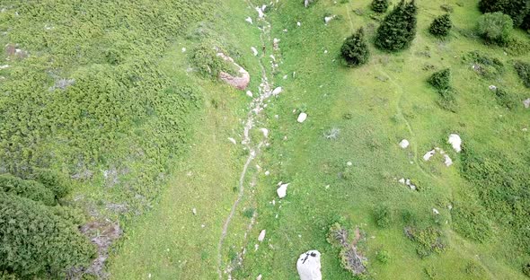 A Guy with a Backpack is Walking in the Mountains