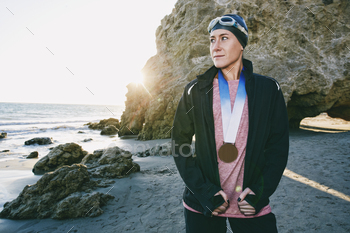 Young woman, triathlete in jacket with a large medal around her neck / Photodune, Misc