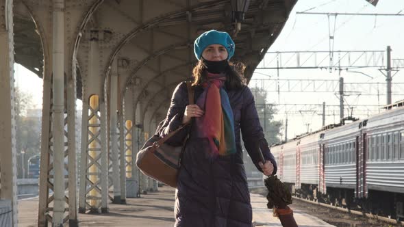 Female in Coat Walking Along Railway Platform