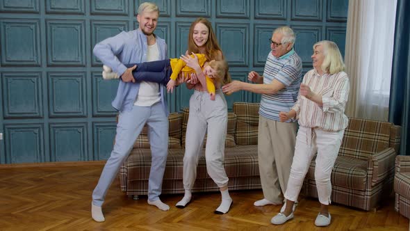 Family Members of Different Generations Having Fun Listening Music Dancing Crazy in Room at Home