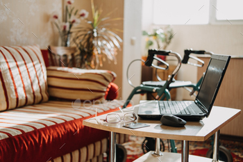 ity medical insurance policy for Seniors. Laptop, glasses and documents on the background of Rollator Mobility Walker for Seniors at home
