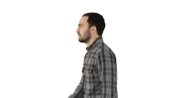 Confident casual man walking forward on white background.