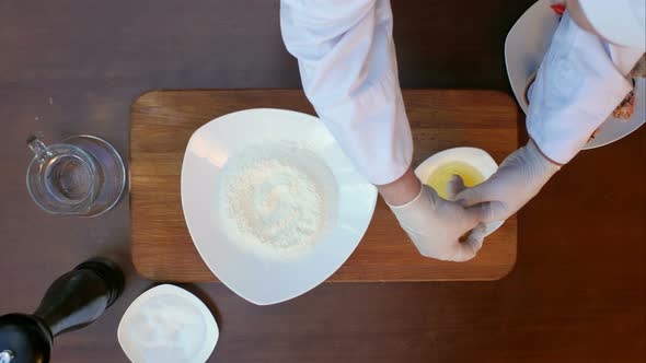 Putting Egg Yolk in the Flour on the Plate