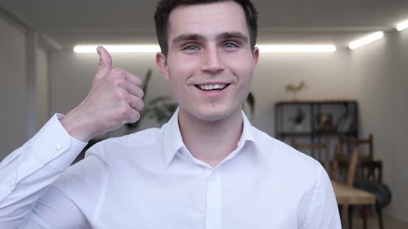 Thumbs Up by Businessman at Work,  Looking at Camera