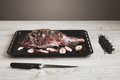 Pre cooked lamb leg on black roasting plate top view - PhotoDune Item for Sale
