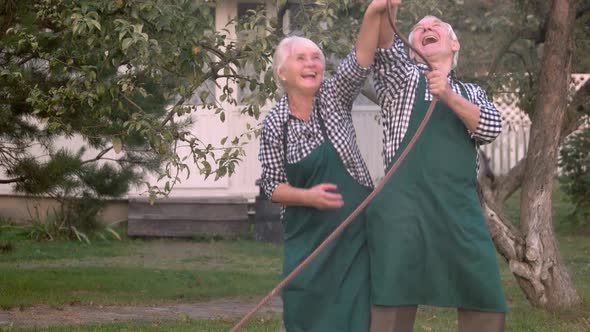 Elderly Couple with Garden Hose