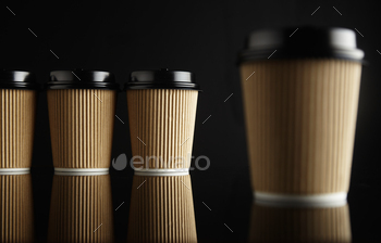 ctive table against black background, plus one same cup closer and out of focus