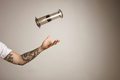 Tattoed man's arm throwing and catching aeropress - PhotoDune Item for Sale