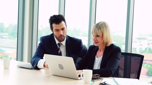 Two Business People Talk Project Strategy at Office