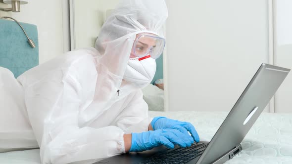 Woman in Protective Biohazard Suit Working Remotely From Home During Lockdown