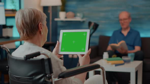 Adult in Wheelchair Holding Digital Tablet with Green Screen