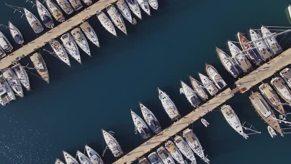 Aerial top-down view of docked sailboats.