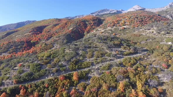 A drone flies over the rocks and slopes of  Dry Creek Trailhead in Alpine, Utah as leaves change int