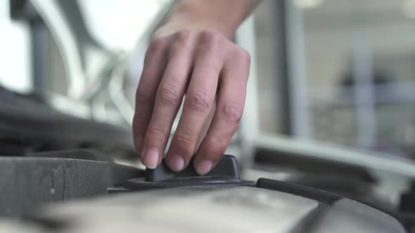 Worker Mechanic Screwing an Important Klapon Part Into Hood of Car After Testing in Car Service