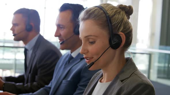 Young business people wearing headsets in a modern office