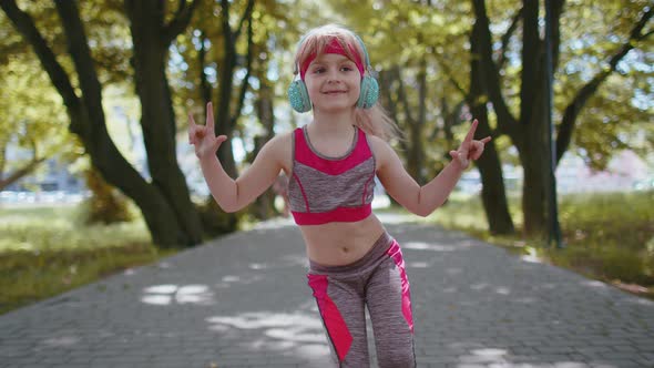 Sport Runner Child Girl Training Exercise Listening Music on Headphones Dancing to Camera Having Fun